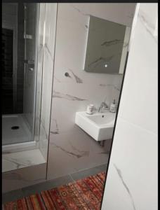 a white bathroom with a sink and a mirror at Schöne und gemütliche Wohnung in Holzwickede in Holzwickede +1 photo