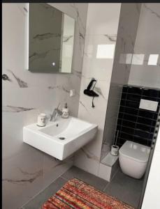 a white bathroom with a sink and a toilet at Schöne und gemütliche Wohnung in Holzwickede in Holzwickede