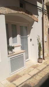 a white house with two potted plants in front of it at MandorleOlio Versomare in Polignano a Mare