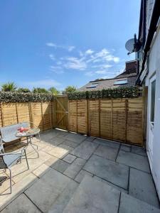 a patio with a table and a fence at Hillbarn Studio Free Parking & Private Patio in Worthing
