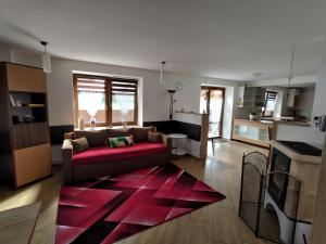 a living room with a couch and a red rug at Apartmán Sázava - Žďársko in Sázava
