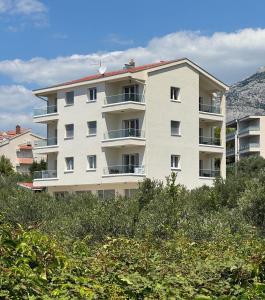 a large white apartment building on top of a hill at Olive Garden in Promajna