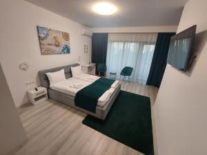 a bedroom with a bed with a green and white blanket at NoMi Ultracentral Apartments in Târgu-Mureş