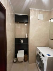 a bathroom with a toilet and a washing machine at Prime Browary Apartment in Warsaw +17 photos