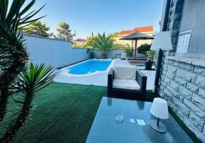 a patio with a chair and a swimming pool at Apartmani Vernissage in Biograd na Moru