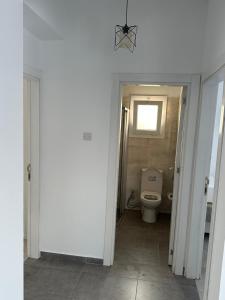 a bathroom with a toilet and a window at Sessiz tesisi in Kyrenia