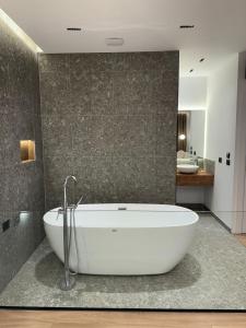 a bathroom with a white tub in a room at Hotel Jurgen in Lezhë