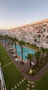 un complexe d'appartements avec piscine et palmiers dans l'établissement Shems Bouznika, à Bouznika