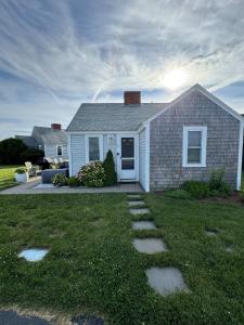 ein Haus mit Rasen mit Steppsteine im Hof in der Unterkunft Charming Cottage with Amazing Views in Truro
