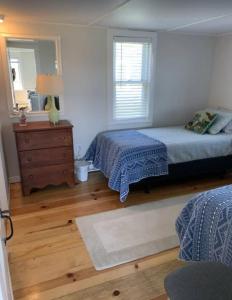 1 Schlafzimmer mit 2 Betten, einer Kommode und einem Spiegel in der Unterkunft Charming Cottage with Amazing Views in Truro