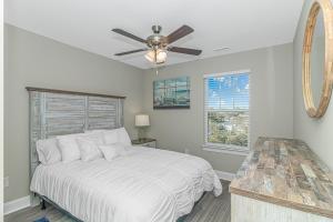 a bedroom with a bed and a ceiling fan at Coastal Oasis walk to the beach in Myrtle Beach +29 photos