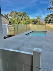 a swimming pool on a patio with a fence at Coastal Oasis walk to the beach in Myrtle Beach