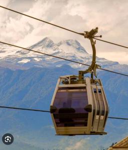 a ski lift with a snow covered mountain in the background at Edificio Urban Frente universidad Autónoma in Manizales +2 photos