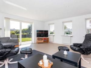 a living room with black leather furniture and a flat screen tv at 4 star holiday home in Blokhus-By Traum in Blokhus