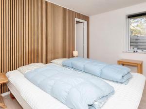 a bedroom with a bed with blue pillows on it at 4 star holiday home in Blokhus-By Traum in Blokhus