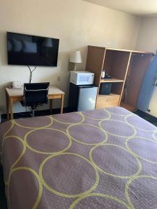a room with a bed and a desk and a tv at SureStay by Best Western Walla Walla in Walla Walla