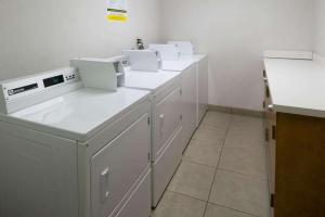 a kitchen with white counters and white appliances at SureStay by Best Western Walla Walla in Walla Walla
