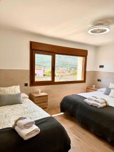 a bedroom with two beds and a window at El Balcón De Gredos in Navaluenga +69 photos