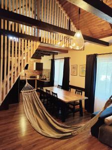 a hammock in a living room with a table and chairs at Osada Brzeziny in Brzeziny
