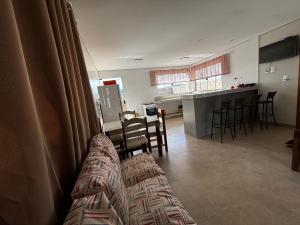 a living room with a couch and a kitchen at Casa de Temporada Carrancas-MG in Carrancas +15 photos