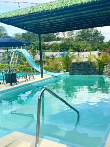 a pool with a slide in a resort at Villa Tungara in Bejuco