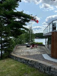 a bench on a patio next to a building with a flag at Suite Sunrise in Maclennan Township