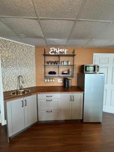 a kitchen with a white refrigerator and a sink at Suite Sunrise in Maclennan Township
