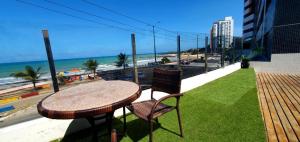 a table and chairs on a balcony with a view of the beach at Golden Tower - Flat a Beira Mar in Natal