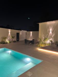 a swimming pool in a yard at night at Cove Chalet 1شاليه كوڤ in Al Ahsa