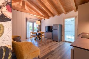 a kitchen and living room with a table and a refrigerator at BORGO STALIS RESORT in Sesto al Reghena