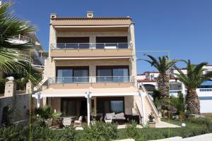 a house with a balcony and palm trees at Villa Sunset Siviri in Siviri