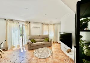 a living room with a couch and a flat screen tv at Nido de Mar entre Pinos in Benitachell