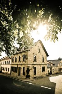 ein altes Steingebäude an der Straßenseite in der Unterkunft Landhotel & Weingut Espenhof in Flonheim