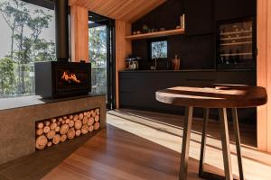 a kitchen with a fireplace and a stool in front of it at Hunter Huon Valley Cabin One in Glen Huon