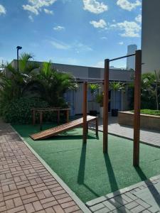 um parque com um banco de madeira em um gramado em Apartamento novo, vista mar, 150m da praia em Piçarras