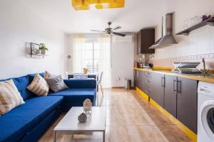 salon z niebieską kanapą i kuchnią w obiekcie Amura Motril. Apartamento con garaje w mieście Motril