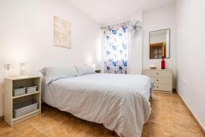 biała sypialnia z łóżkiem i oknem w obiekcie Amura Motril. Apartamento con garaje w mieście Motril