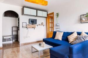 salon z niebieską kanapą i stołem w obiekcie Amura Motril. Apartamento con garaje w mieście Motril