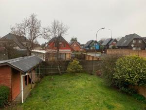 a house with a yard with a fence and houses at Hospedaje Casa Mirador in Puerto Montt