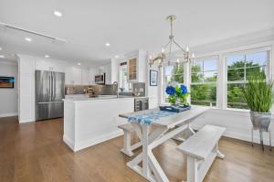 a white kitchen with a table and a dining room at 27 Clam Shell Drive Chatham - Need A Name in Chatham