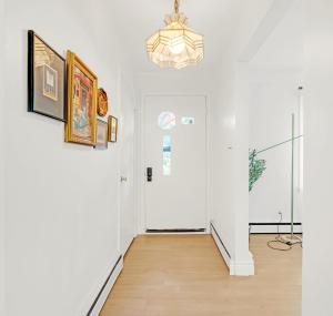 un couloir avec des murs blancs et une porte blanche dans l'établissement Walk to Lake - Old Town Retreat, à Niagara on the Lake