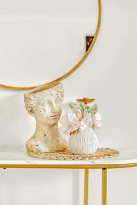 un vase assis sur une table sous un miroir dans l'établissement Walk to Lake - Old Town Retreat, à Niagara on the Lake 51 autres photos