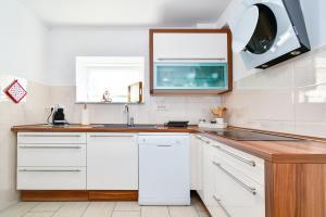 eine Küche mit weißen Schränken und einer Spüle in der Unterkunft Family friendly house with a parking space Bribir, Novi Vinodolski - 23378 in Bribir + 10 Fotos