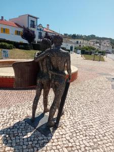 a statue of two people holding a cane at Sol Mar in Odeceixe