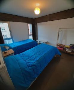 ein Schlafzimmer mit zwei blauen Betten und einem Spiegel in der Unterkunft Sarmiento 430 in San Salvador de Jujuy