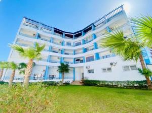a large white building with palm trees in front of it at Cabo Dream a Cabo Negro in Cabo Negro