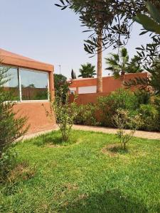 a house with a yard with grass and trees at La Villa Olive in Riaïna