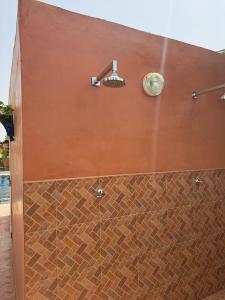 a bathroom with a brown wall with a shower at Atlas Garden Villa in Riaïna +1 photo