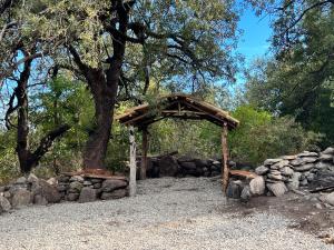 a wooden bench and a stone wall at REFUGIOS de MONTAÑA CABEZA DEL INDI0 in Merlo