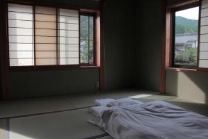Rúm í herbergi á Guest House Kurukuru ゲストハウスくるくる